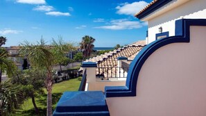 A building with a curved balcony overlooking a garden and a view of the sea. - Aptos Leo San Bruno I Ii (Ayamonte)