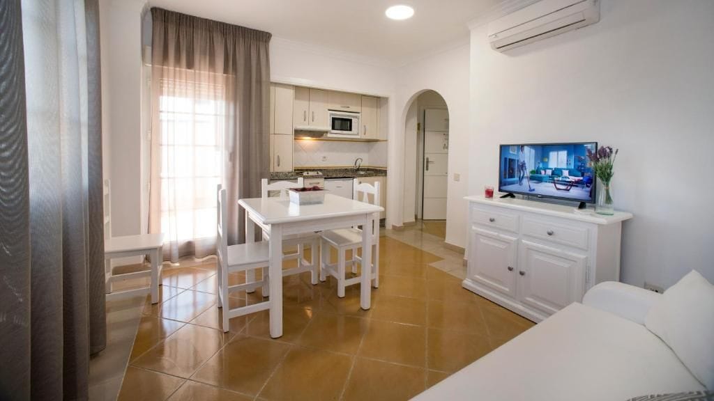 A compact living space with a kitchenette, a dining area, and a seating area.
