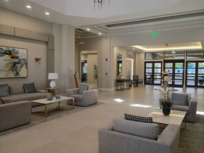 A spacious lobby with a reception desk, seating area, and artwork on the walls. - Cozy 1-bed 1bath apt in five star neighborhood with incredible amenities (Boynton Beach)