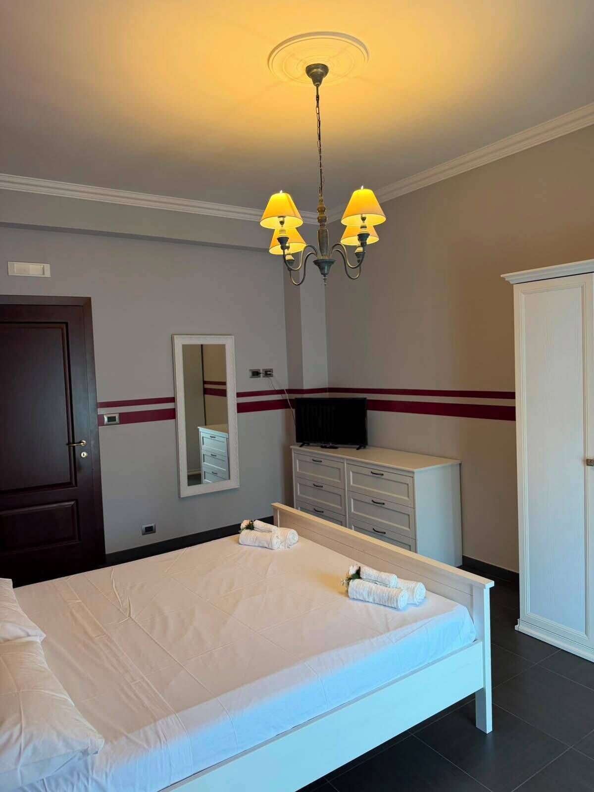 Une chambre d’hôtel avec un lit, une armoire, une télévision et un miroir.