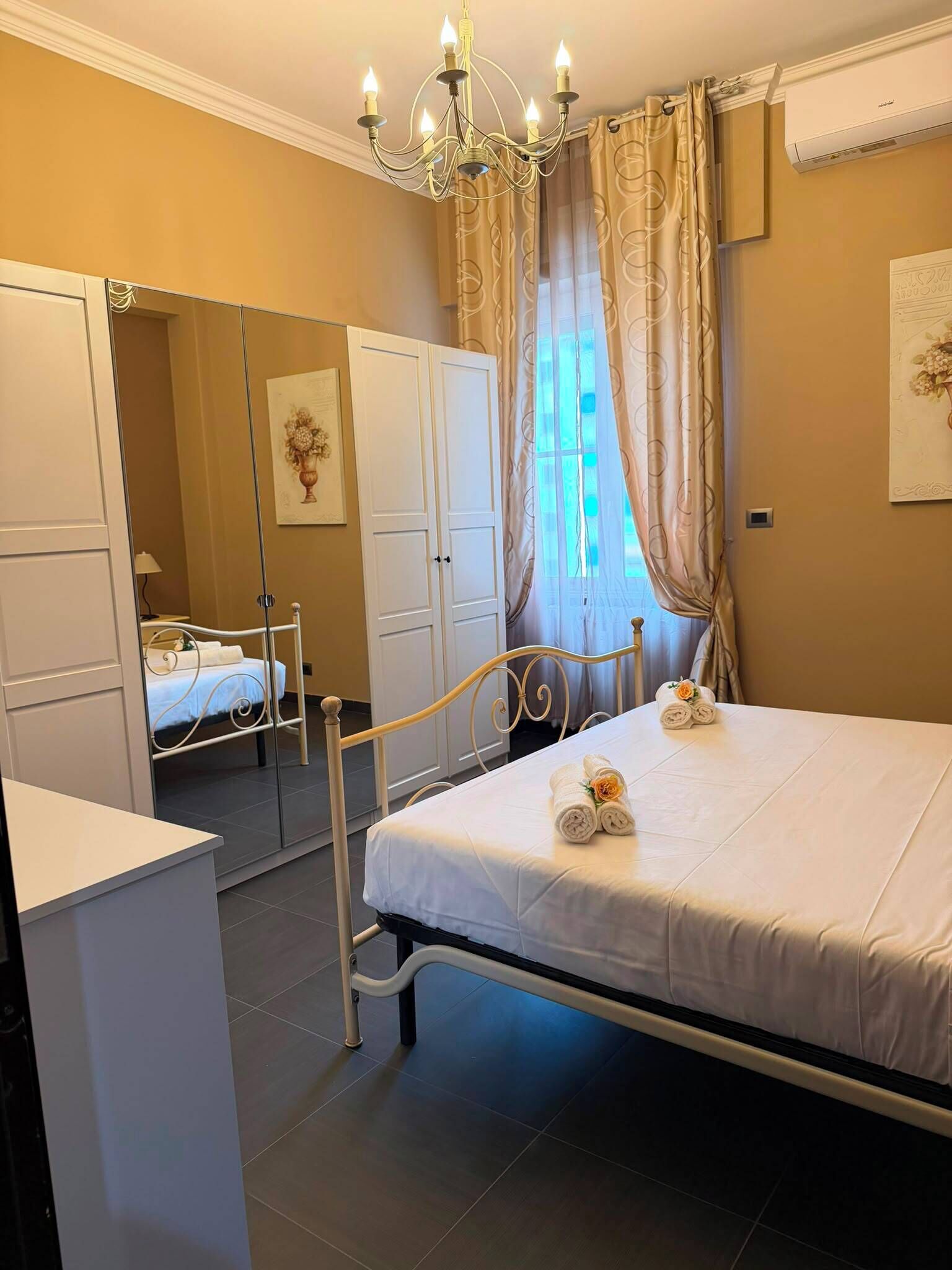 Une chambre d’hôtel avec un lit, un bureau, une armoire et un miroir.