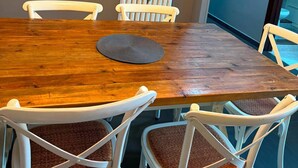 A conference room with a wooden table, white chairs, a flat-screen TV, and a radiator. - Apartment located in a prime location in Ostia Lido (Lido di Ostia)