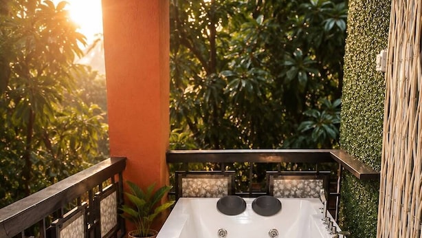 A spa area with a hot tub, wicker furniture, and potted plants.
