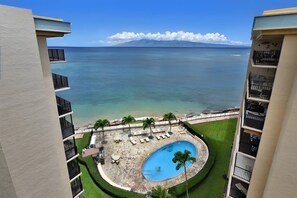 A pool surrounded by lounge chairs and a view of the ocean. - Sunny 4BR, 2 Condos for 12 in Lahaina, Hawaii! (Lahaina)
