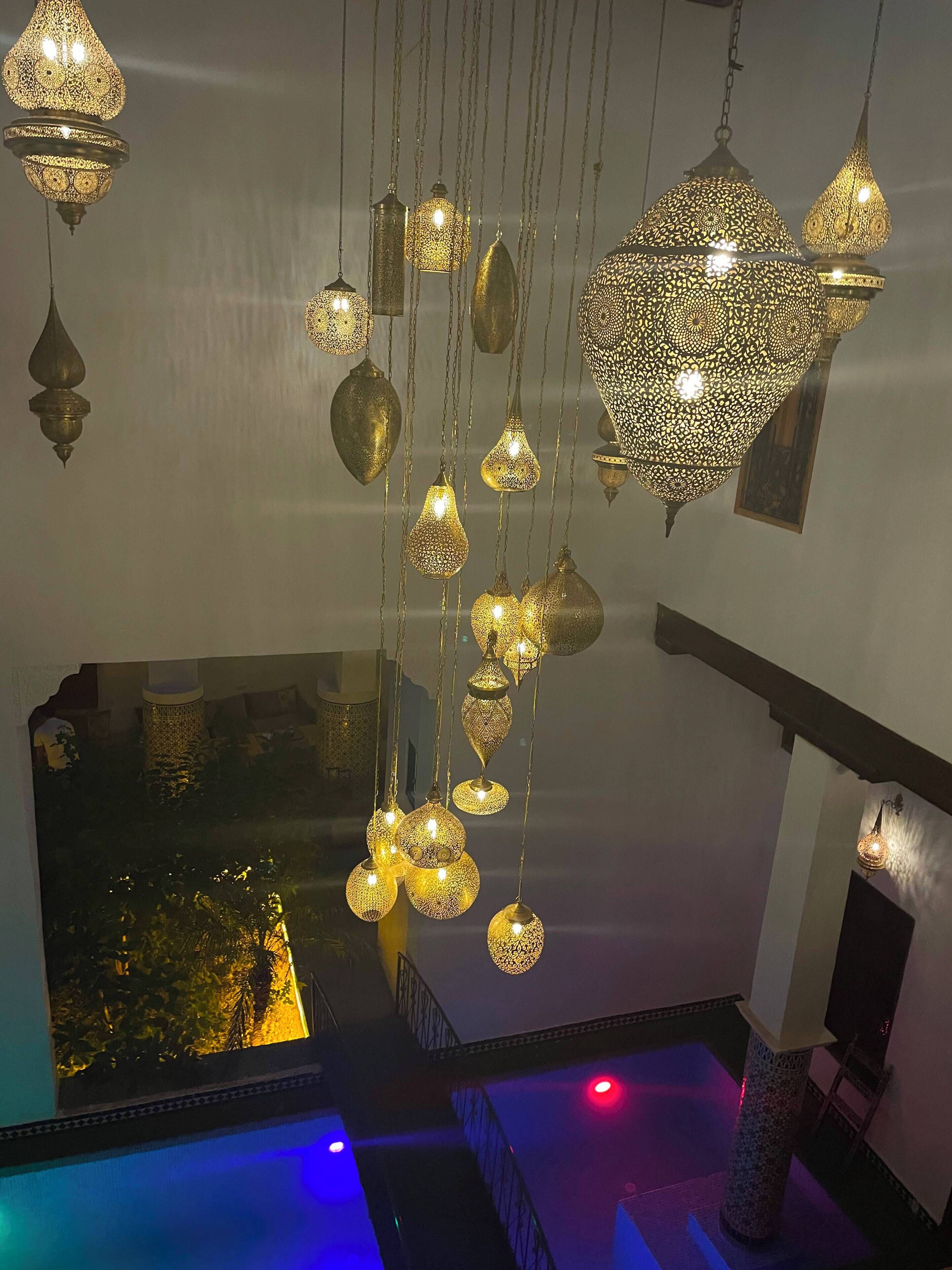A room with hanging decorative light fixtures and a view of a pool area.