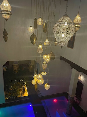 A room with hanging decorative light fixtures and a view of a pool area. - Riad Old city palace  (Fes)