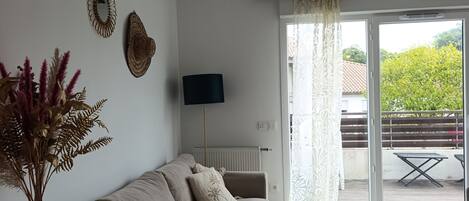 Ein modernes Wohnzimmer mit einer Couch, einem Couchtisch und Blick auf einen Balkon.