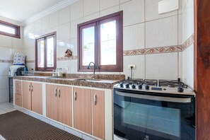 A kitchen with a stove, sink, and cabinets. - Mansão-7quartos em Porto de Galinhas-165 (Camela)