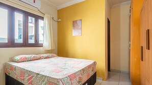 A bedroom with a bed, a window, an air conditioning unit, and a wooden wardrobe. - Mansão-7quartos em Porto de Galinhas-165 (Camela)