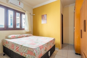 A bedroom with a bed, a window, an air conditioning unit, and a wooden wardrobe. - Mansão-7quartos em Porto de Galinhas-165 (Camela)