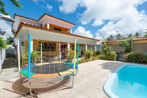 A pool area with a hammock and a covered seating area. - Mansão-7quartos em Porto de Galinhas-165 (Camela)