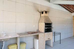 A brick-built outdoor oven with a chimney, a sink, and a trash bin. - Mansão-7quartos em Porto de Galinhas-165 (Camela)