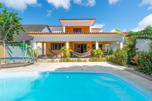 A two-story house with a swimming pool in the foreground. - Mansão-7quartos em Porto de Galinhas-165 (Camela)