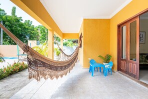 Ein Zimmer mit einer Hängematte, blauen Stühlen und einer Tür.