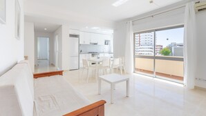 Um apartamento moderno com varanda, área de refeições e cozinha.