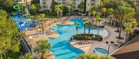 A resort with multiple swimming pools, palm trees, and a water slide.