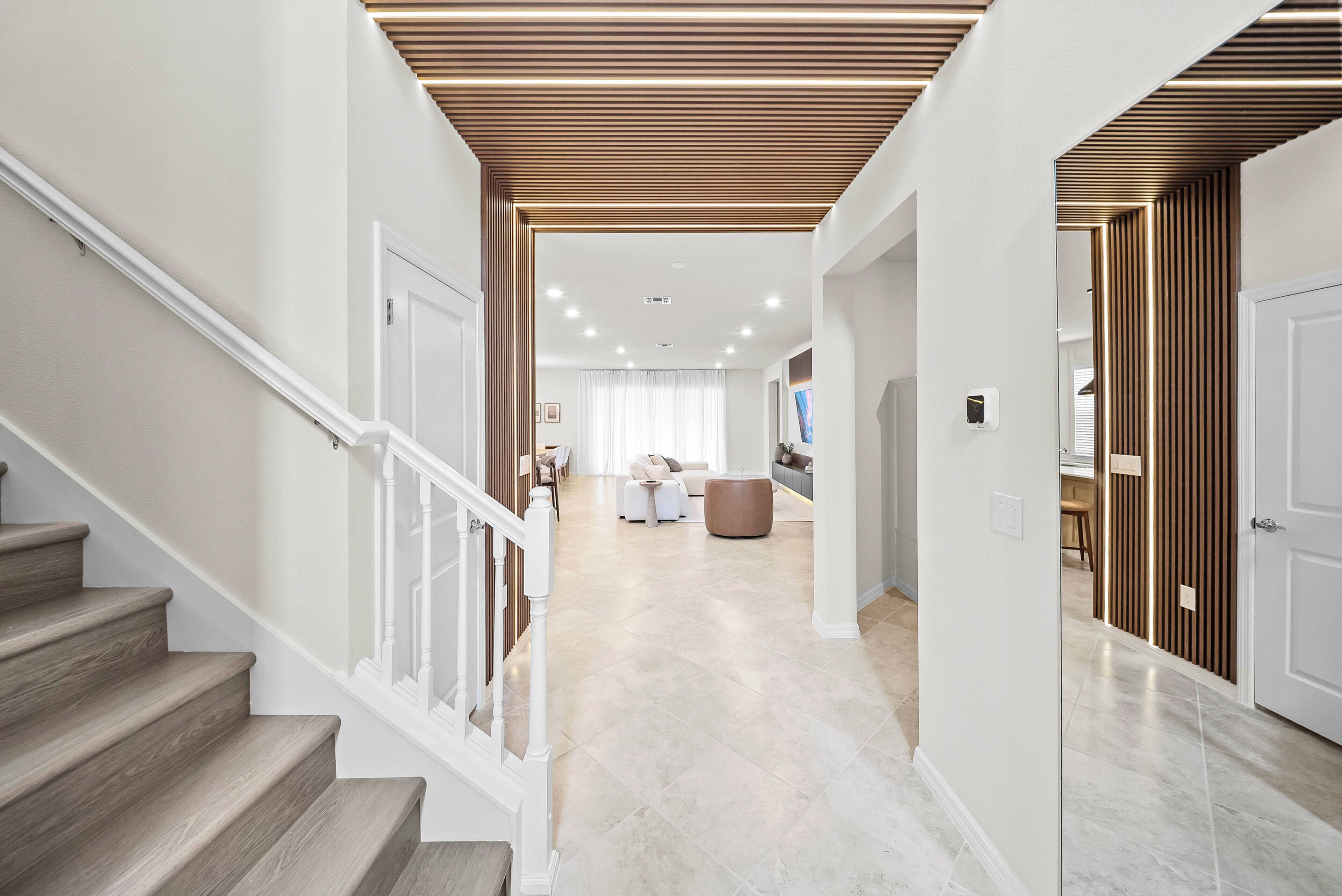 A modern interior with a staircase, a living area, and a kitchen.