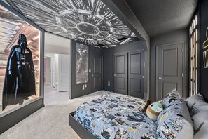 A bedroom with a bed, a ceiling with a circular design, and a door with a keyhole. - 8BR house with private pool and game room (Clermont)