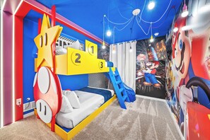 Ein Spielzimmer für Kinder mit einem Etagenbett, einer Rutsche und einer Wandmalerei.
