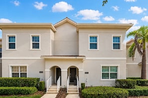 A two-story building with a symmetrical facade, numbered addresses, and a central entrance with steps. - 4BR house sleeps 10 with private pool in kissimmee (Kissimmee)