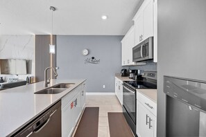 A modern kitchen with stainless steel appliances, a built-in oven, and a microwave. - 4BR house sleeps 10 with private pool in kissimmee (Kissimmee)