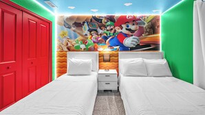 Ein Hotelzimmer mit zwei Betten, einer roten Tür und einem Wandgemälde zum Thema Mario.