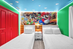 A hotel room with two beds, a red door, and a Mario-themed mural on the wall. - 4BR house sleeps 10 with private pool in kissimmee (Kissimmee)