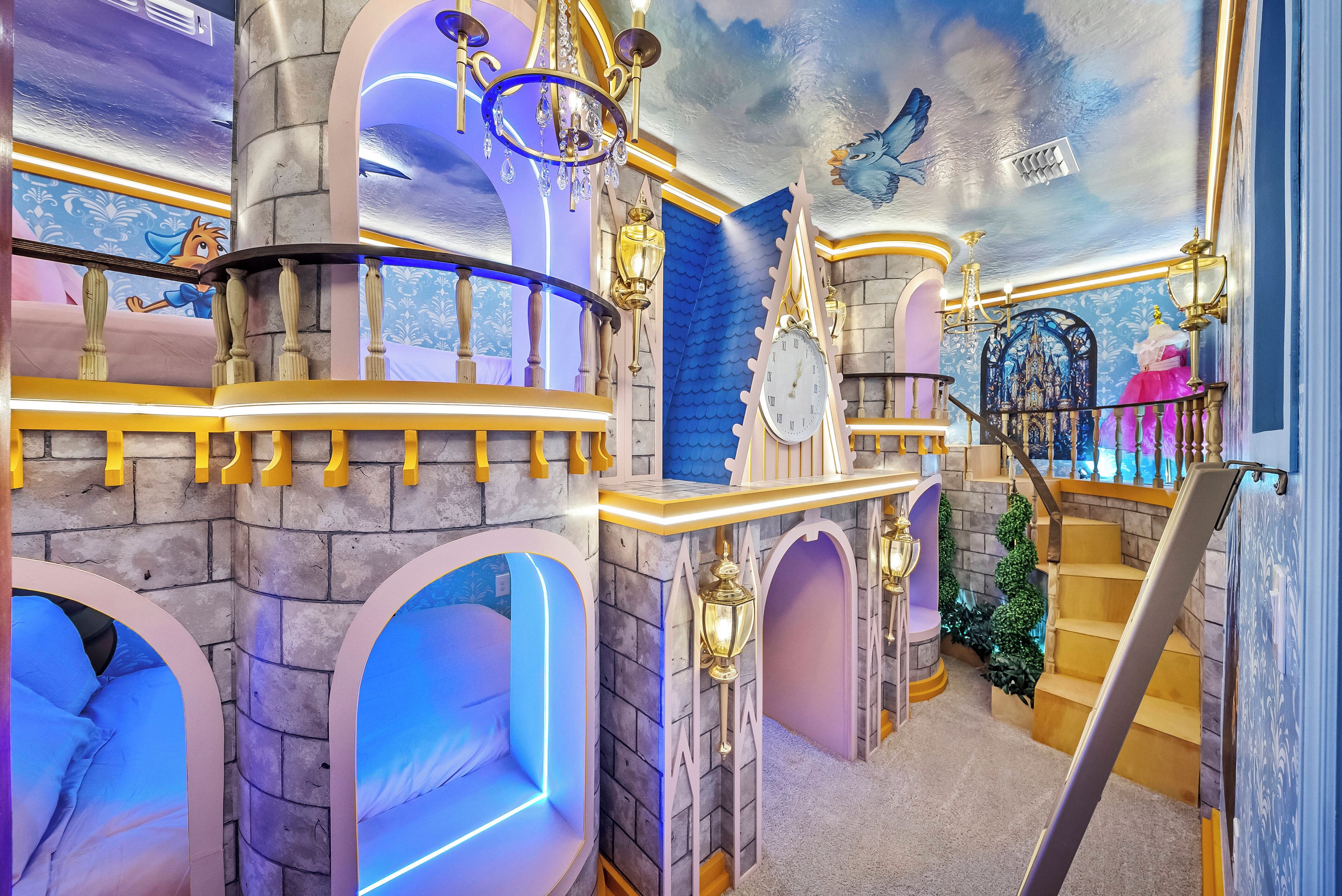 Une pièce avec un escalier, un lustre et une horloge.