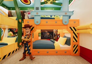 Ein Kinderspielzimmer mit einem Etagenbett, einer Figurenfigur und verschiedenen Spielzeugen.