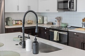 A modern kitchen with a sleek faucet, a microwave, and a stainless steel sink. - Escape To The Sage Room 2 BR Suite Tempe Town Lake (Tempe)