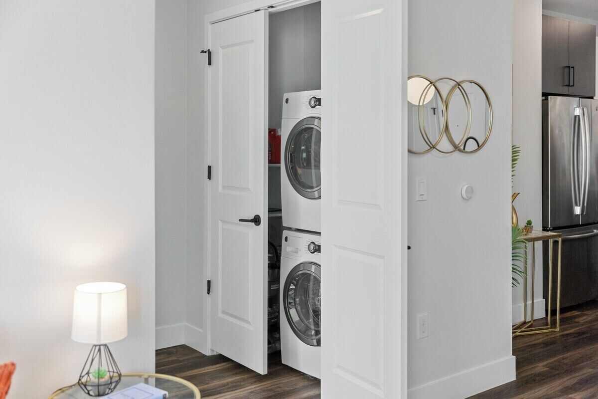 A laundry room with two washing machines, a door, and a refrigerator.