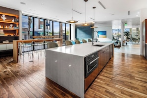 A modern kitchen with a large island, bar seating, and a view of the outdoors. - Escape To The Twilight Bungalow 1BR Tempe TownLake (Tempe)