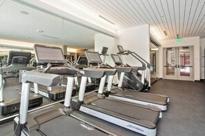Ein Fitnessstudio mit Laufbändern, Crosstrainern und Ergometer.