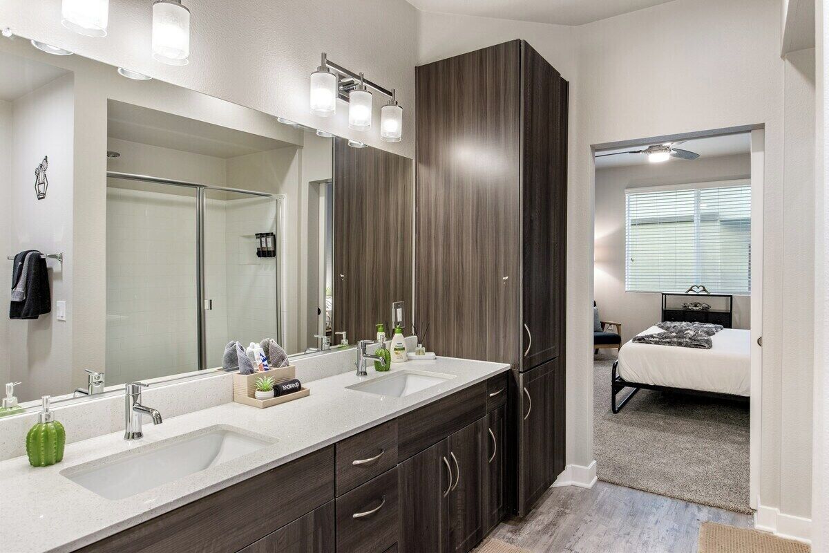 A modern bathroom with a double sink vanity, a large mirror, and a walk-in shower.