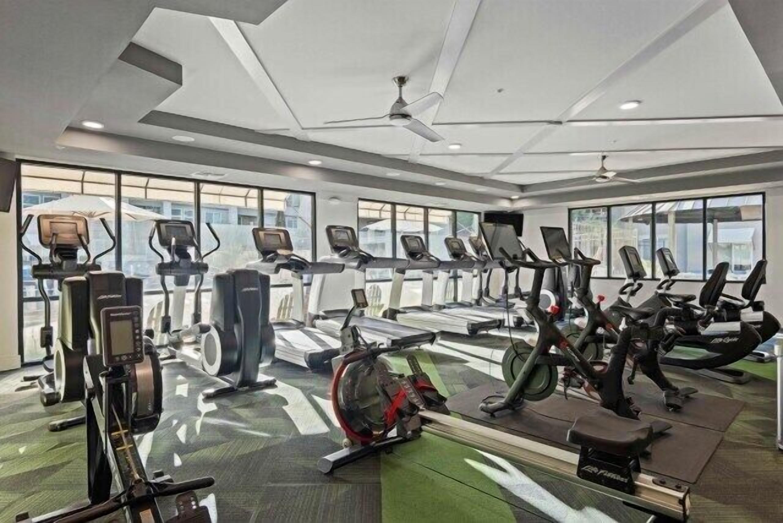 A gym with treadmills, stationary bikes, and elliptical machines.