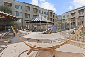 A hammock in a courtyard with a building in the background. - Escape To N. Scottsdale Modern & Chic 1BR Suite (Phoenix)