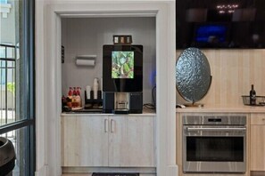 A kitchenette with a water dispenser, a flat-screen TV, and a decorative egg shell. - Escape To Hollywood Hideaway 2BR King Bed Suite (Phoenix)
