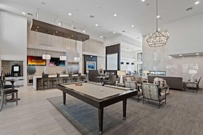 A modern living room with a pool table, comfortable seating, a bar area, and a large mirror. - Escape to N. Scottsdale 1BR Bohemian Desert Dream (Phoenix)