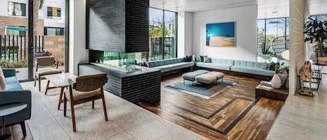 A modern lobby with a fireplace, seating area, and large windows.