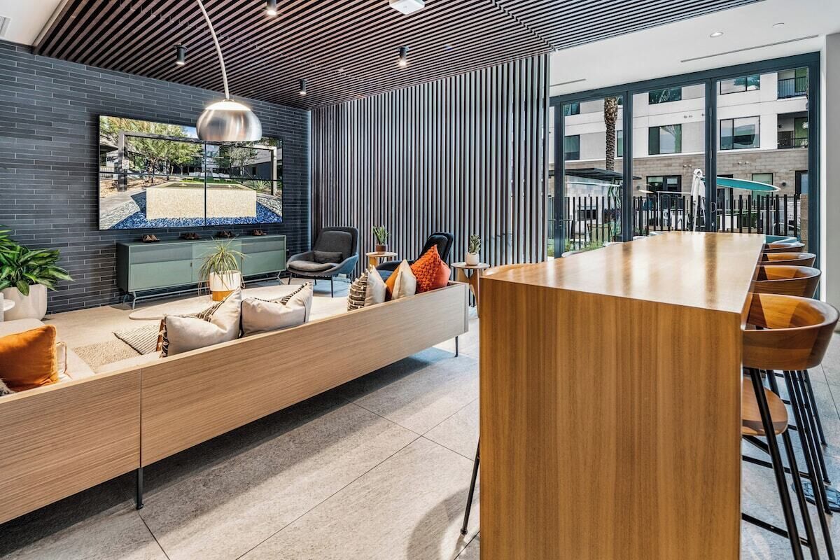 Een modern interieur met een lange houten bank, een bar en een groot raam met uitzicht op buiten.