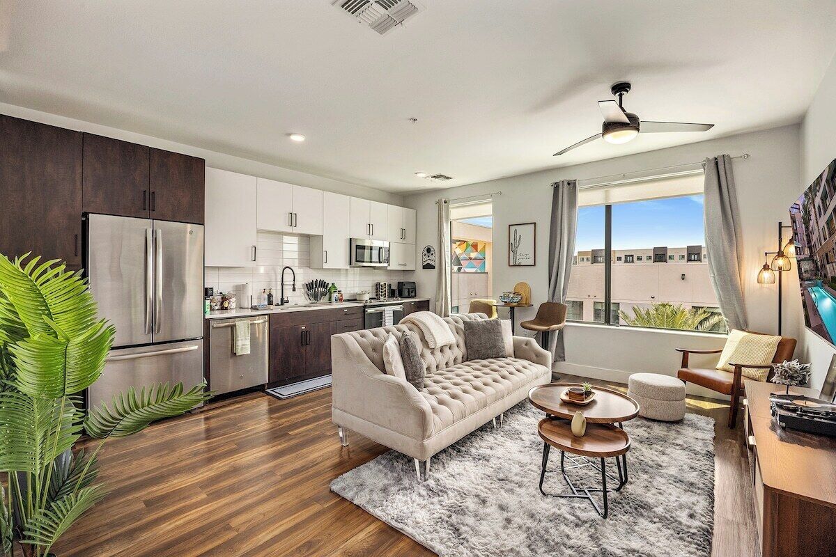 Ein modernes Apartment mit Küche, Wohnbereich und einem Balkon mit Blick auf die Stadt.
