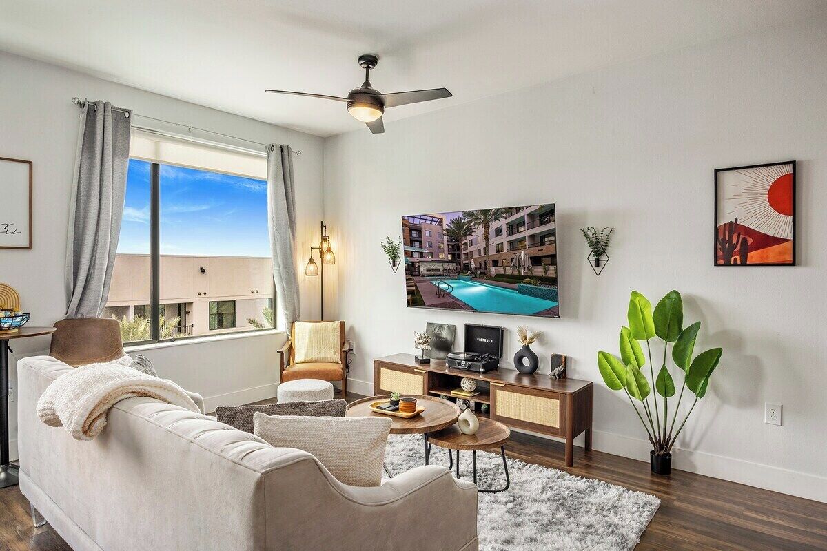 A modern living room with a sofa, a coffee table, a TV, and a plant.
