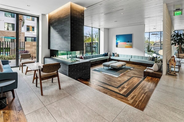 A modern lobby with a fireplace, seating area, and large windows. - Escape To The Tempe Penthouse King Bed Studio (Tempe)