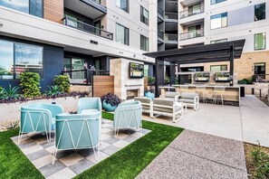 A modern outdoor living area with a patio, seating, and a barbecue setup. - Escape To The Tempe Penthouse King Bed Studio (Tempe)