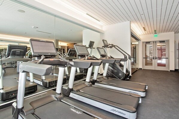 Ein Fitnessstudio mit Laufbändern, Ergometer und Crosstrainern.
