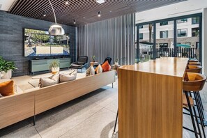 Ein modernes Interieur mit einer langen Holzbank, einer Bar und einem großen Fenster mit Blick nach draußen.