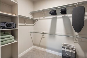 Un armario con estantes, una barra para colgar ropa y un contenedor de almacenamiento.
