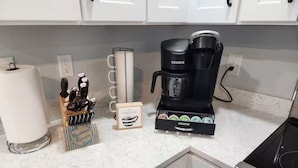 A kitchen with a coffee maker, a microwave, and a set of knives.