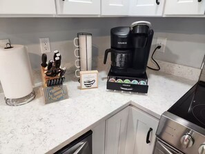 A kitchen with a coffee maker, a microwave, and a set of knives.