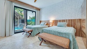 A hotel room with two beds, a bench, a ceiling fan, and a view of an outdoor pool. - Casa VistaMar Spacious 5-bedroom villa built around a tree! (Potrero)